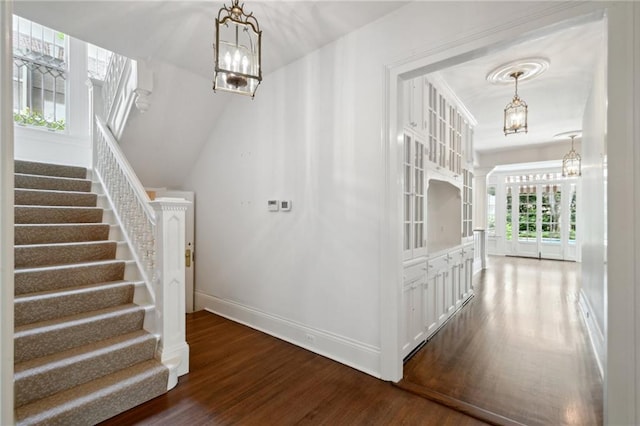1923 State St, New Orleans, LA 70118 - staircase featuring a chandelier, wood finished floors, and baseboards