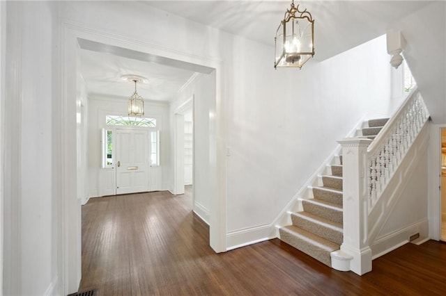 1923 State St, New Orleans, LA 70118 - foyer entrance featuring a chandelier, dark wood-style floors, stairway, baseboards, and crown molding