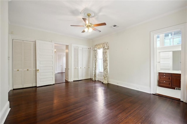 1923 State St, New Orleans, LA 70118 - unfurnished bedroom with dark wood finished floors, baseboards, two closets, ornamental molding, and ceiling fan