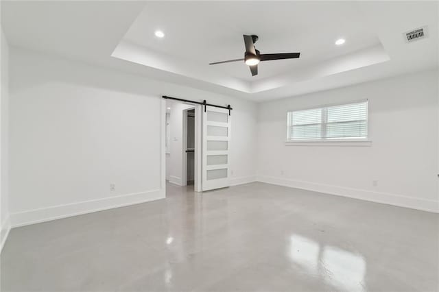 3705 James Dr, Metairie, LA 70003 - unfurnished bedroom featuring a tray ceiling, a barn door, finished concrete flooring, recessed lighting, and baseboards