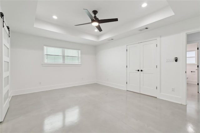 3705 James Dr, Metairie, LA 70003 - unfurnished bedroom featuring a raised ceiling, concrete flooring, recessed lighting, a barn door, and a closet