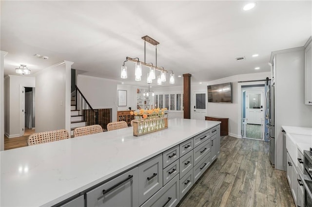 5844 Fleur De Lis Dr, New Orleans, LA 70124 - kitchen featuring gray cabinetry, stainless steel refrigerator, wood finished floors, baseboards, and pendant lighting