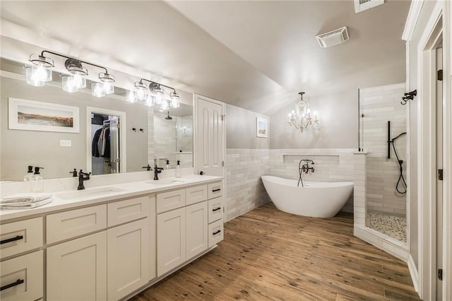 5844 Fleur De Lis Dr, New Orleans, LA 70124 - bathroom with tiled shower, double vanity, tile walls, a freestanding bath, and a chandelier