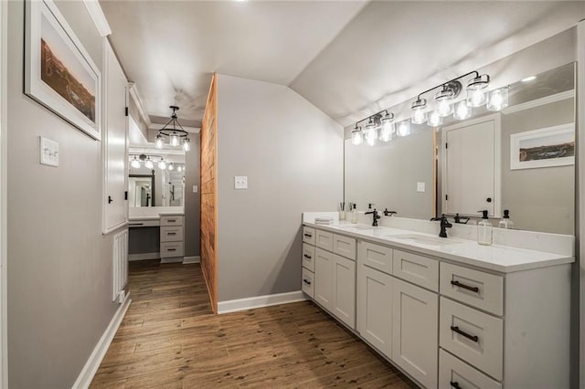 5844 Fleur De Lis Dr, New Orleans, LA 70124 - bathroom featuring double vanity, wood finished floors, baseboards, and vaulted ceiling