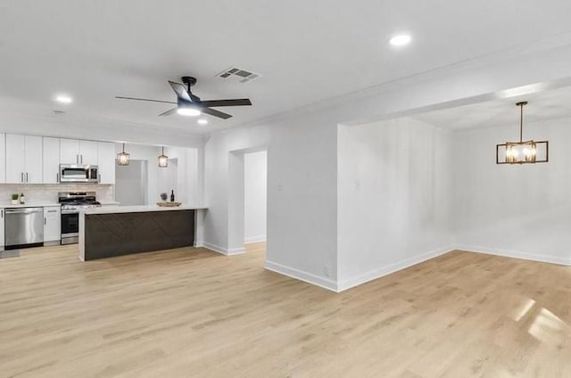 1705 Haring Rd, Metairie, LA 70001 - kitchen with appliances with stainless steel finishes, open floor plan, light wood-style flooring, light countertops, and recessed lighting