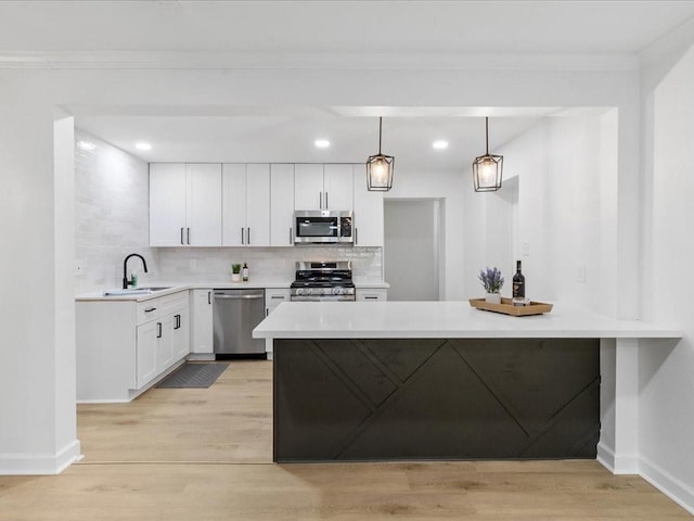 1705 Haring Rd, Metairie, LA 70001 - kitchen featuring stainless steel appliances, light wood-style flooring, a sink, crown molding, and baseboards