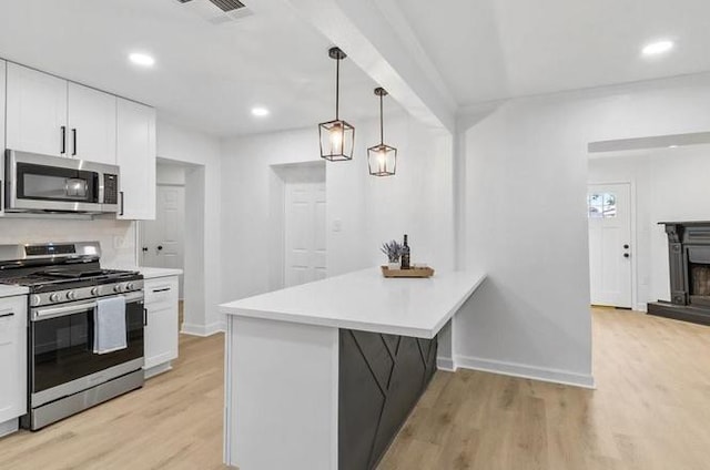 1705 Haring Rd, Metairie, LA 70001 - kitchen with appliances with stainless steel finishes, white cabinetry, light wood-style floors, light countertops, and a peninsula