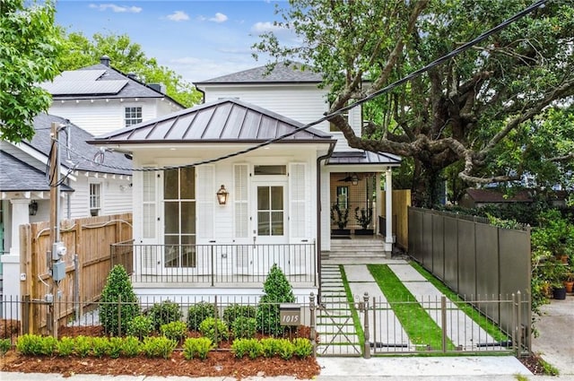 1015 Cadiz St, New Orleans, LA 70115 - shotgun-style home with covered porch, a standing seam roof, a fenced front yard, metal roof, and a gate