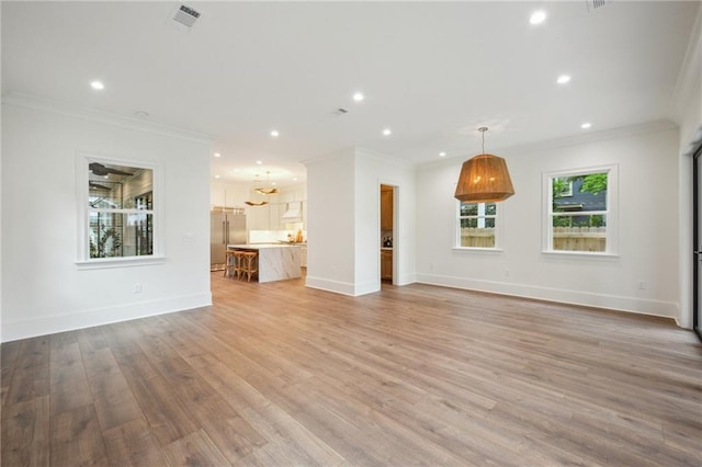 1015 Cadiz St, New Orleans, LA 70115 - unfurnished living room with crown molding, recessed lighting, light wood-style flooring, and baseboards