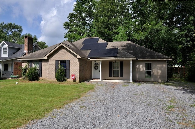 1613 Live Oak St, Slidell, LA 70460 - view of front of house with gravel driveway, solar panels, brick siding, a porch, and a shingled roof