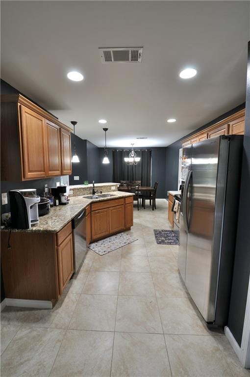 1613 Live Oak St, Slidell, LA 70460 - kitchen featuring stainless steel appliances, a peninsula, brown cabinetry, a chandelier, and hanging light fixtures