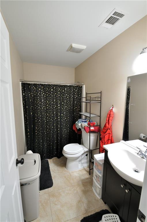 1613 Live Oak St, Slidell, LA 70460 - full bath with tile patterned floors, vanity, and a shower with curtain