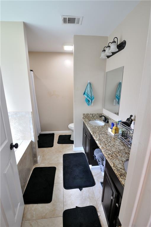 1613 Live Oak St, Slidell, LA 70460 - full bathroom featuring vanity, tiled bath, and tile patterned floors