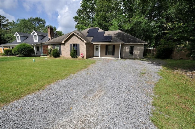1613 Live Oak St, Slidell, LA 70460 - ranch-style house with gravel driveway, solar panels, covered porch, brick siding, and a chimney