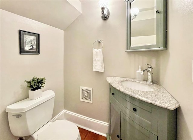 714 Third St, New Orleans, LA 70130 - half bath featuring toilet, vanity, wood finished floors, vaulted ceiling, and baseboards