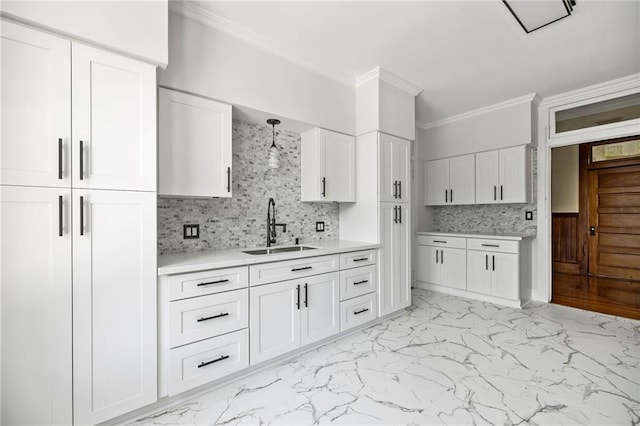215 N 6th St, Ponchatoula, LA 70454 - kitchen with a sink, ornamental molding, light countertops, light marble finish flooring, and white cabinets
