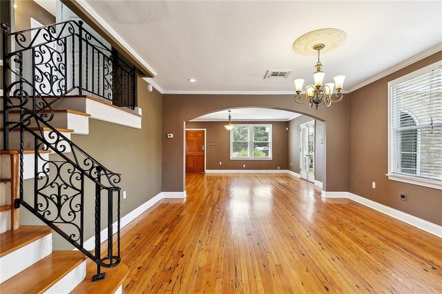 4959 Elysian Fields Ave, New Orleans, LA 70122 - unfurnished room with arched walkways, crown molding, baseboards, hardwood / wood-style floors, and a chandelier