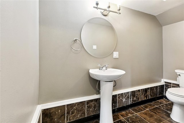 4959 Elysian Fields Ave, New Orleans, LA 70122 - half bathroom with toilet, marble look tile flooring, and lofted ceiling
