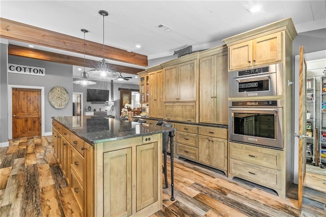 18064 Faller Rd, Tickfaw, LA 70466 - kitchen featuring a kitchen island, a breakfast bar area, ceiling fan, recessed lighting, and beam ceiling