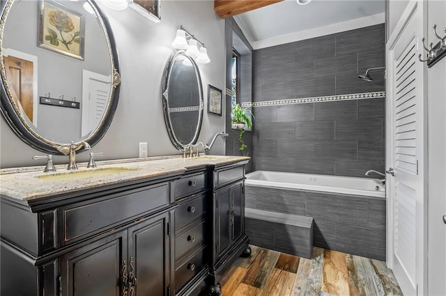 18064 Faller Rd, Tickfaw, LA 70466 - bathroom featuring double vanity, wood finished floors, and tiled shower / bath