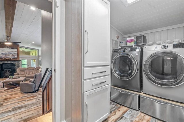 18064 Faller Rd, Tickfaw, LA 70466 - washroom with independent washer and dryer, wood finished floors, a fireplace, and a ceiling fan