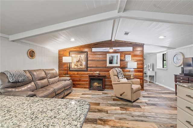 18064 Faller Rd, Tickfaw, LA 70466 - living area featuring wood finished floors, a warm lit fireplace, wooden walls, baseboards, and ceiling fan