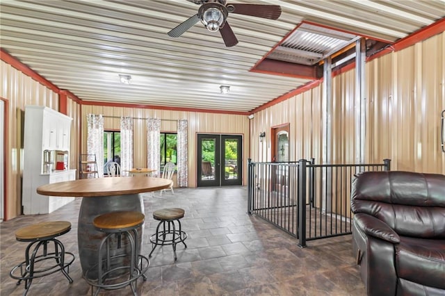 18064 Faller Rd, Tickfaw, LA 70466 - kitchen featuring a ceiling fan, open floor plan, dark stone finish floors, french doors, and a breakfast bar
