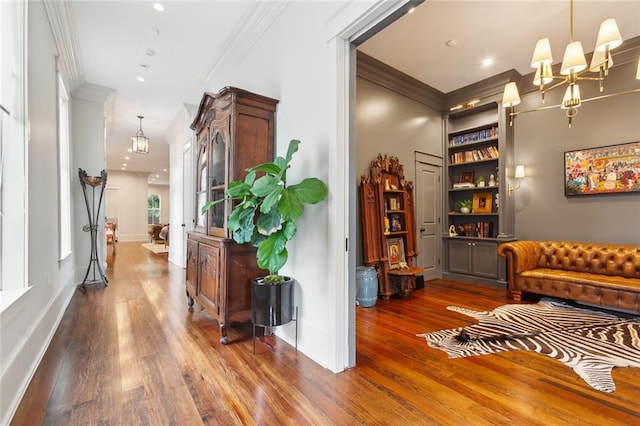 1026 Valence St, New Orleans, LA 70115 - hallway featuring ornamental molding, wood finished floors, a chandelier, recessed lighting, and built in shelves