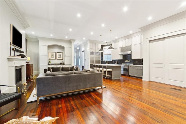 1026 Valence St, New Orleans, LA 70115 - living area featuring ornamental molding, wood finished floors, recessed lighting, and a fireplace