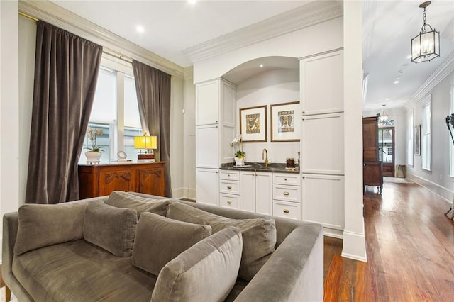 1026 Valence St, New Orleans, LA 70115 - living room with crown molding, wet bar, dark wood-style floors, a chandelier, and baseboards