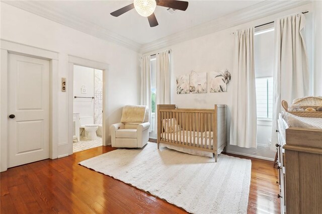1026 Valence St, New Orleans, LA 70115 - bedroom with wood finished floors, multiple windows, a nursery area, crown molding, and a ceiling fan
