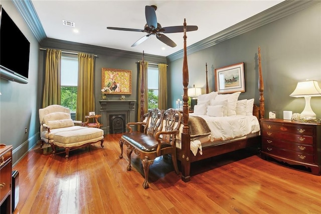 1026 Valence St, New Orleans, LA 70115 - bedroom with hardwood / wood-style flooring, crown molding, a fireplace, baseboards, and a ceiling fan
