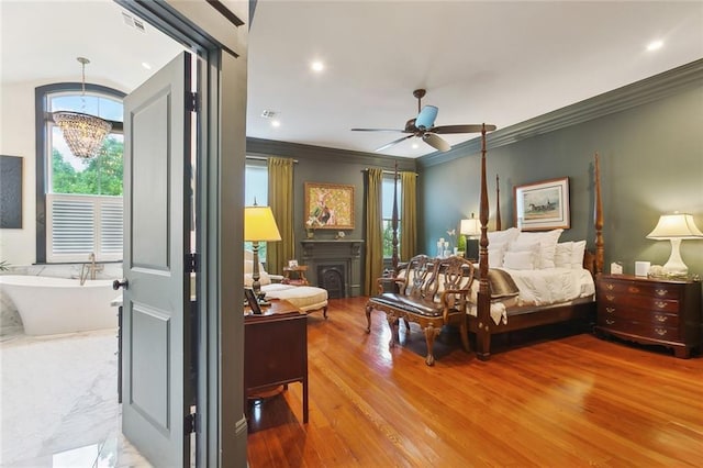 1026 Valence St, New Orleans, LA 70115 - bedroom featuring a chandelier, a fireplace, crown molding, wood finished floors, and recessed lighting