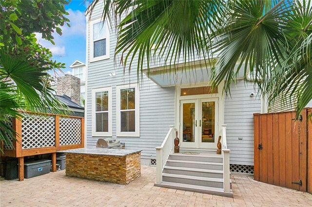 1026 Valence St, New Orleans, LA 70115 - entrance to property with french doors, an outdoor kitchen, and a patio