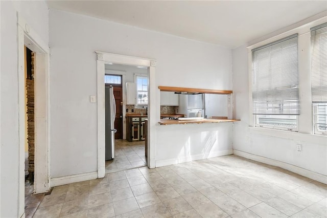 2239 General Taylor St, New Orleans, LA 70115 - unfurnished living room with baseboards and tile patterned flooring