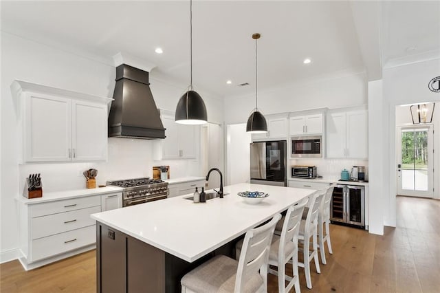 121 Chateau Papillon Ln, Mandeville, LA 70471 - kitchen with appliances with stainless steel finishes, custom exhaust hood, wine cooler, tasteful backsplash, and a breakfast bar area