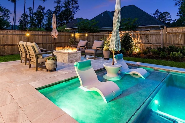 121 Chateau Papillon Ln, Mandeville, LA 70471 - pool at dusk featuring an outdoor fire pit, a patio, and a fenced backyard
