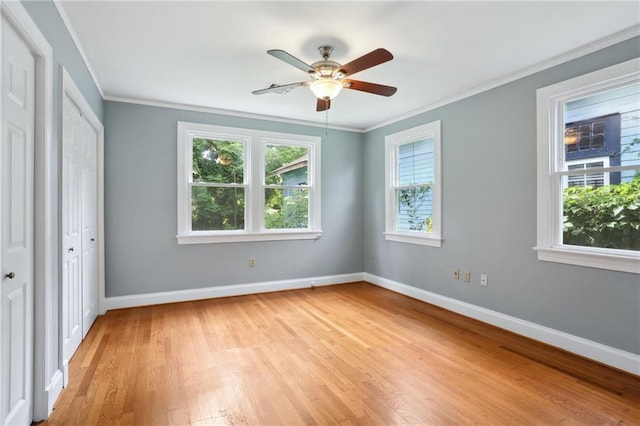 4435 Baccich St, New Orleans, LA 70122 - unfurnished bedroom with light wood-style floors, baseboards, ornamental molding, ceiling fan, and two closets