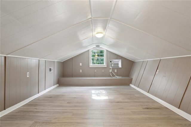 4435 Baccich St, New Orleans, LA 70122 - bonus room featuring wood finished floors, vaulted ceiling, a wall unit AC, baseboards, and wood walls