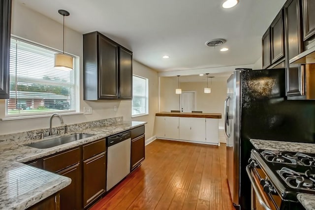 3617 Tartan Dr, Metairie, LA 70003 - kitchen featuring stainless steel dishwasher, light wood-style floors, pendant lighting, dark brown cabinets, and recessed lighting