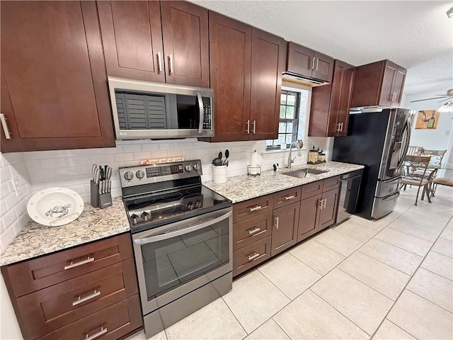 8809 Belle Grove Pl, River Ridge, LA 70123 - kitchen featuring stainless steel appliances, a sink, decorative backsplash, a ceiling fan, and a textured ceiling