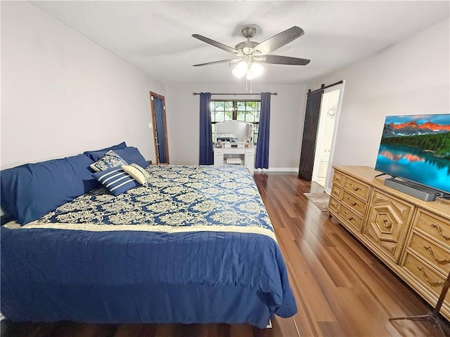 8809 Belle Grove Pl, River Ridge, LA 70123 - bedroom featuring wood finished floors, ceiling fan, and a barn door