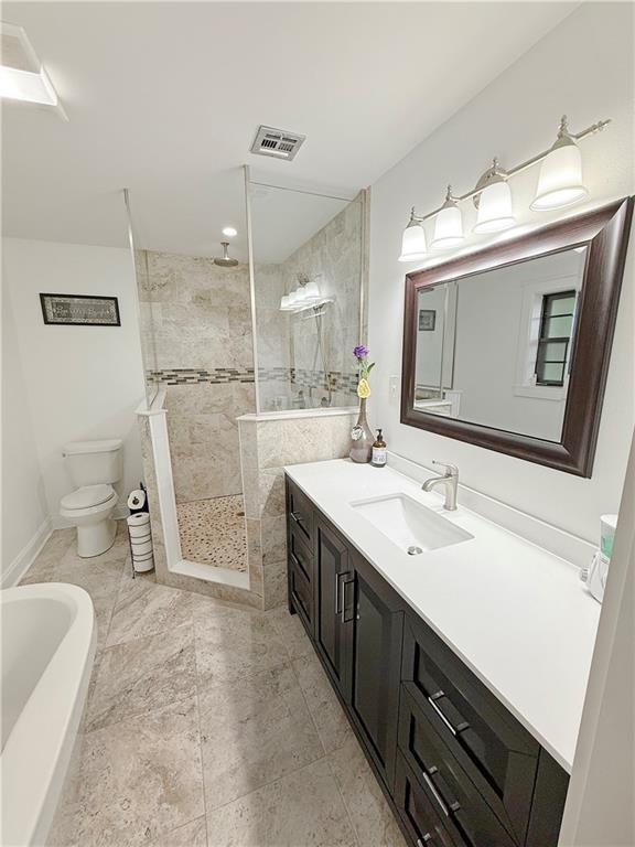 8809 Belle Grove Pl, River Ridge, LA 70123 - bathroom with vanity, toilet, a tile shower, a tub, and baseboards