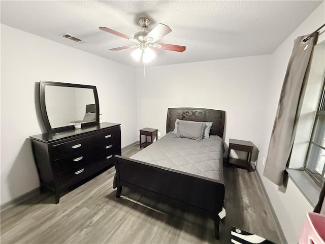 8809 Belle Grove Pl, River Ridge, LA 70123 - bedroom with light wood-style flooring, baseboards, ceiling fan, and a textured ceiling