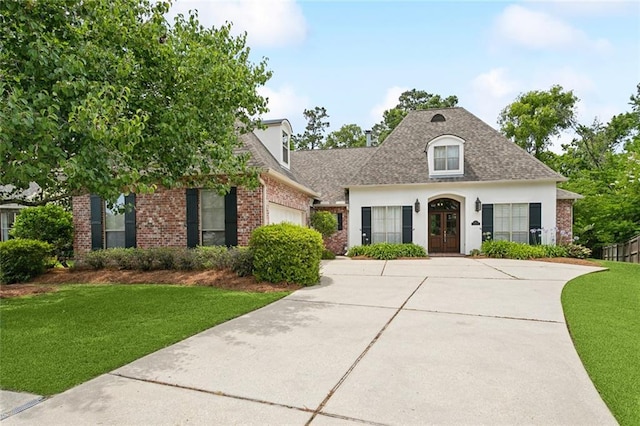 404 Southdown Loop, Covington, LA 70433 - french country style house featuring french doors, an attached garage, concrete driveway, and brick siding