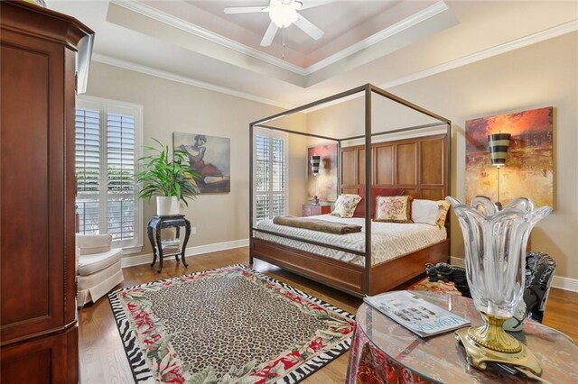 404 Southdown Loop, Covington, LA 70433 - bedroom featuring wood finished floors, a raised ceiling, ornamental molding, baseboards, and ceiling fan