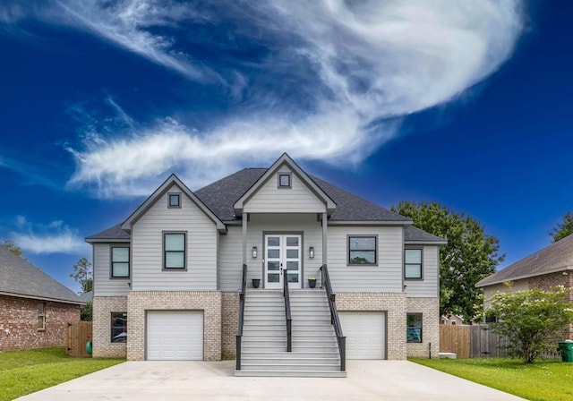 322 Spartan Loop, Slidell, LA 70458 - view of front of property with brick siding, a garage, driveway, roof with shingles, and stairs