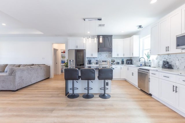 322 Spartan Loop, Slidell, LA 70458 - kitchen featuring appliances with stainless steel finishes, custom range hood, a sink, a kitchen bar, and white cabinets