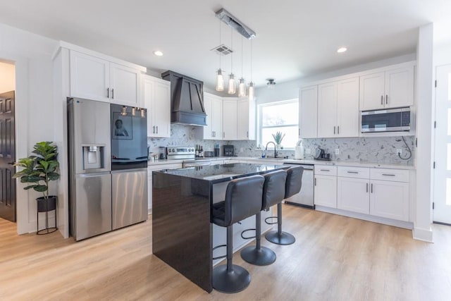 322 Spartan Loop, Slidell, LA 70458 - kitchen with stainless steel appliances, custom range hood, white cabinets, and recessed lighting