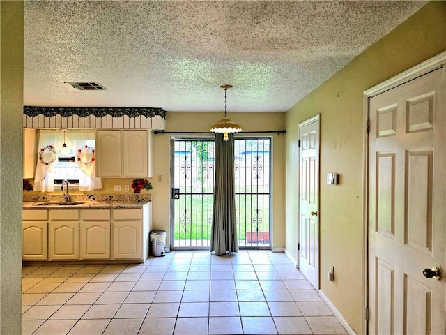 126 Boardwalk St, La Place, LA 70068 - kitchen featuring a sink, light tile patterned flooring, pendant lighting, a textured ceiling, and baseboards